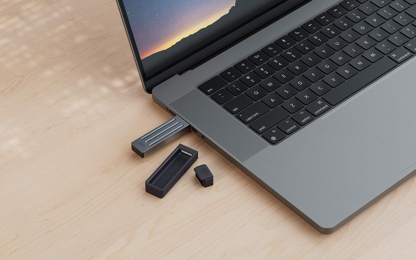 Seagate Ultra Compact external SSD is plugged into a laptop computer with the black protective cover and cap sitting to the side.