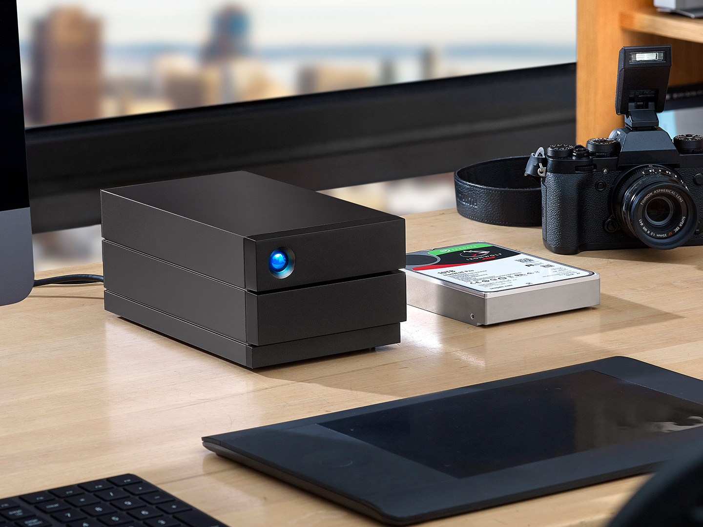 LaCie 2big RAID and portable SSD sit next to an SLR camera. 