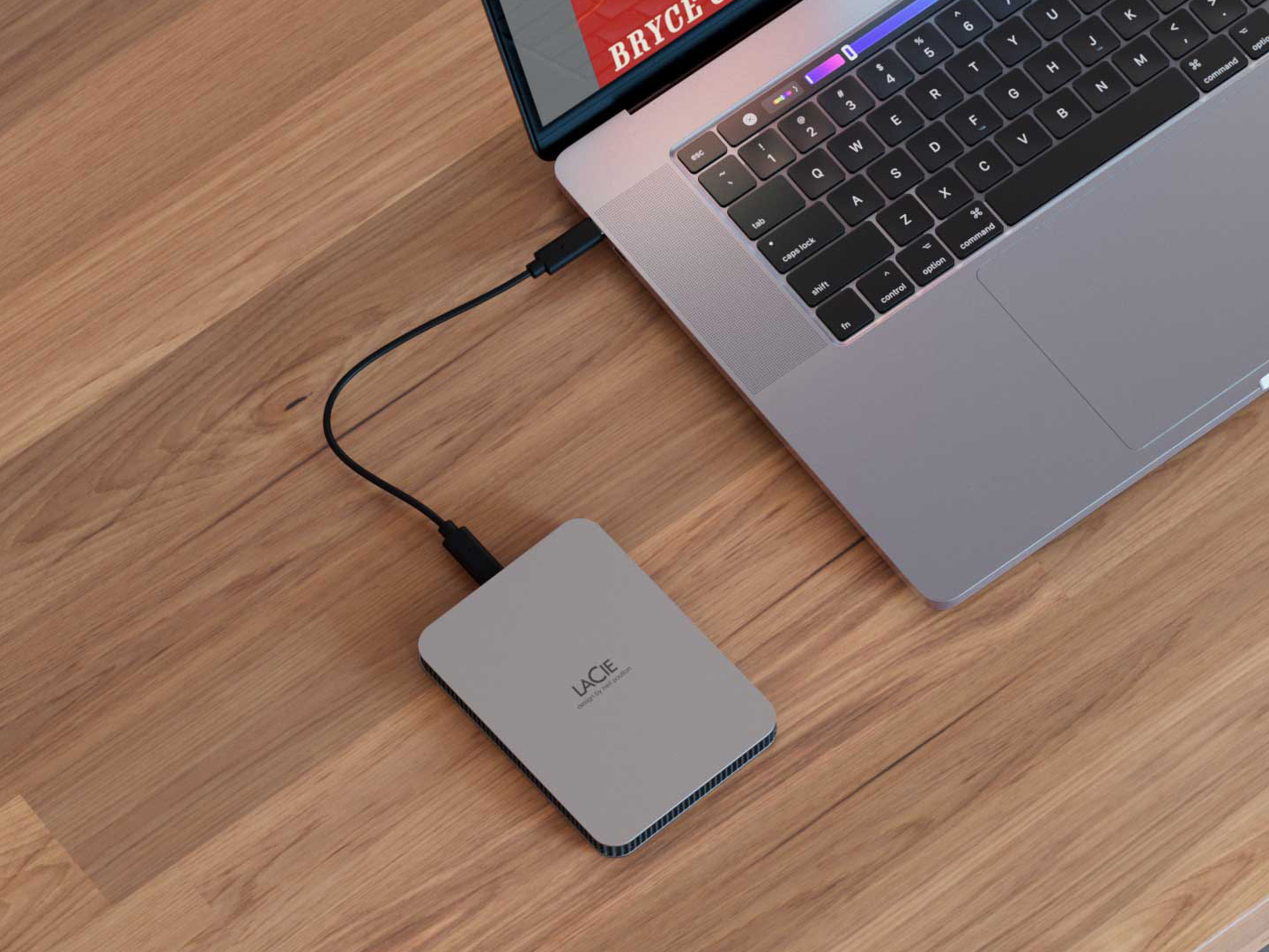 Overhead image of the LaCie mobile Drive Secure is shown connected to a laptop.