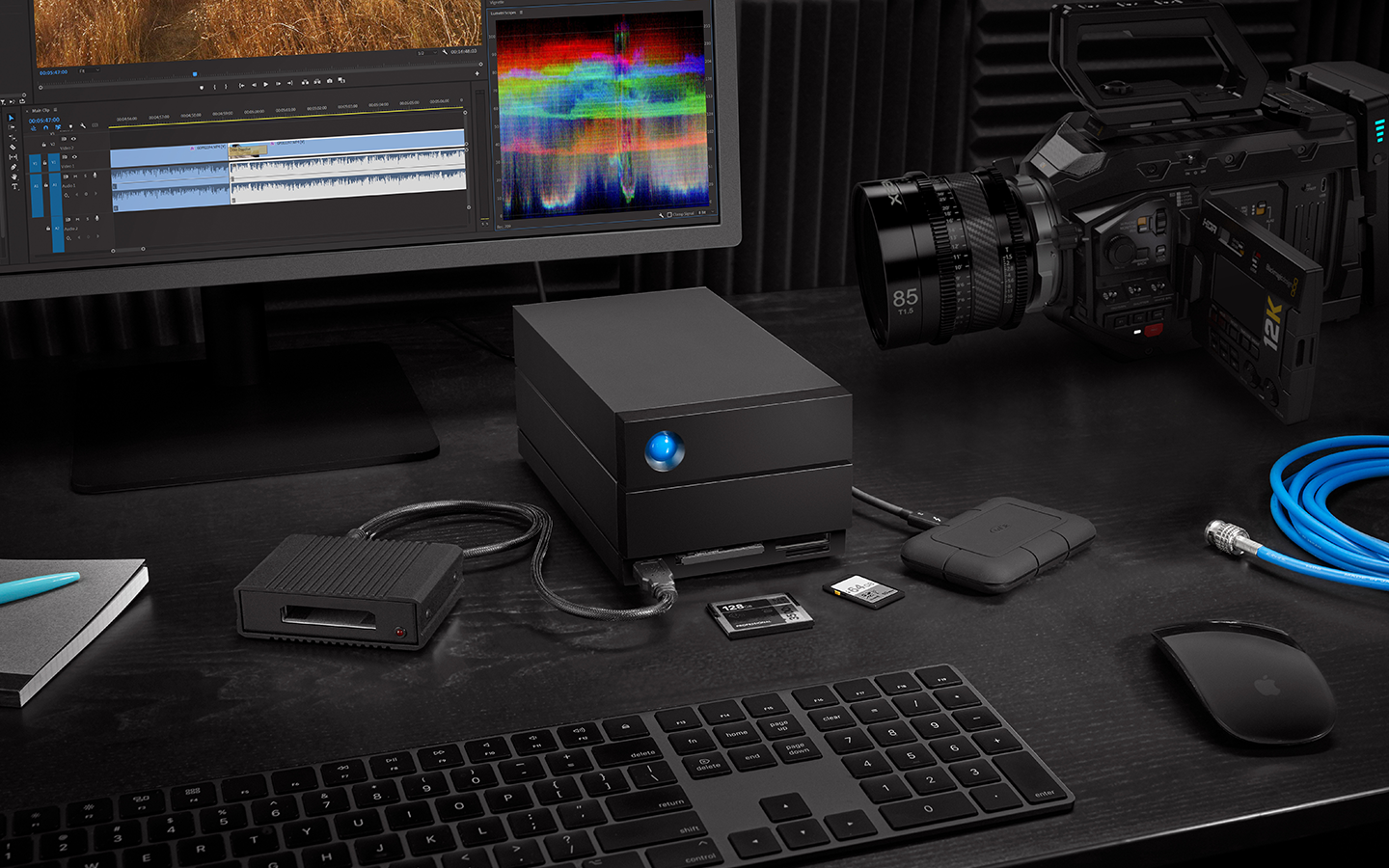 Edit studio features LaCie 2big Dock hard drive, mini drive, desktop, SSD cards, keyboard, and video camera.