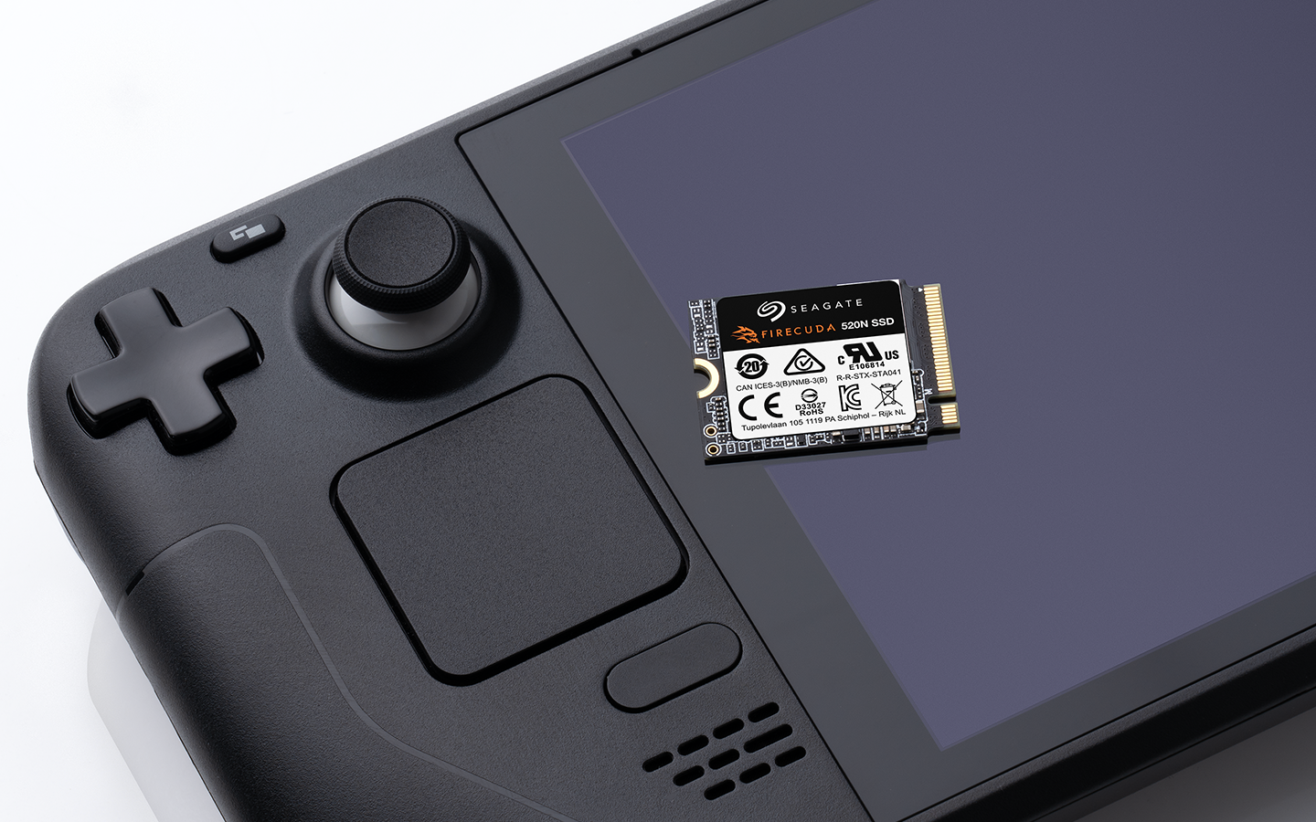 Seagate FireCuda SSD rests on a Steam Deck handheld gaming device screen, showing a close-up of gaming storage hardware.