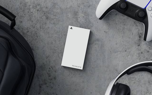 PS5 game controller, headphones and black backpack surround a white Seagate PS5 external storage drive.