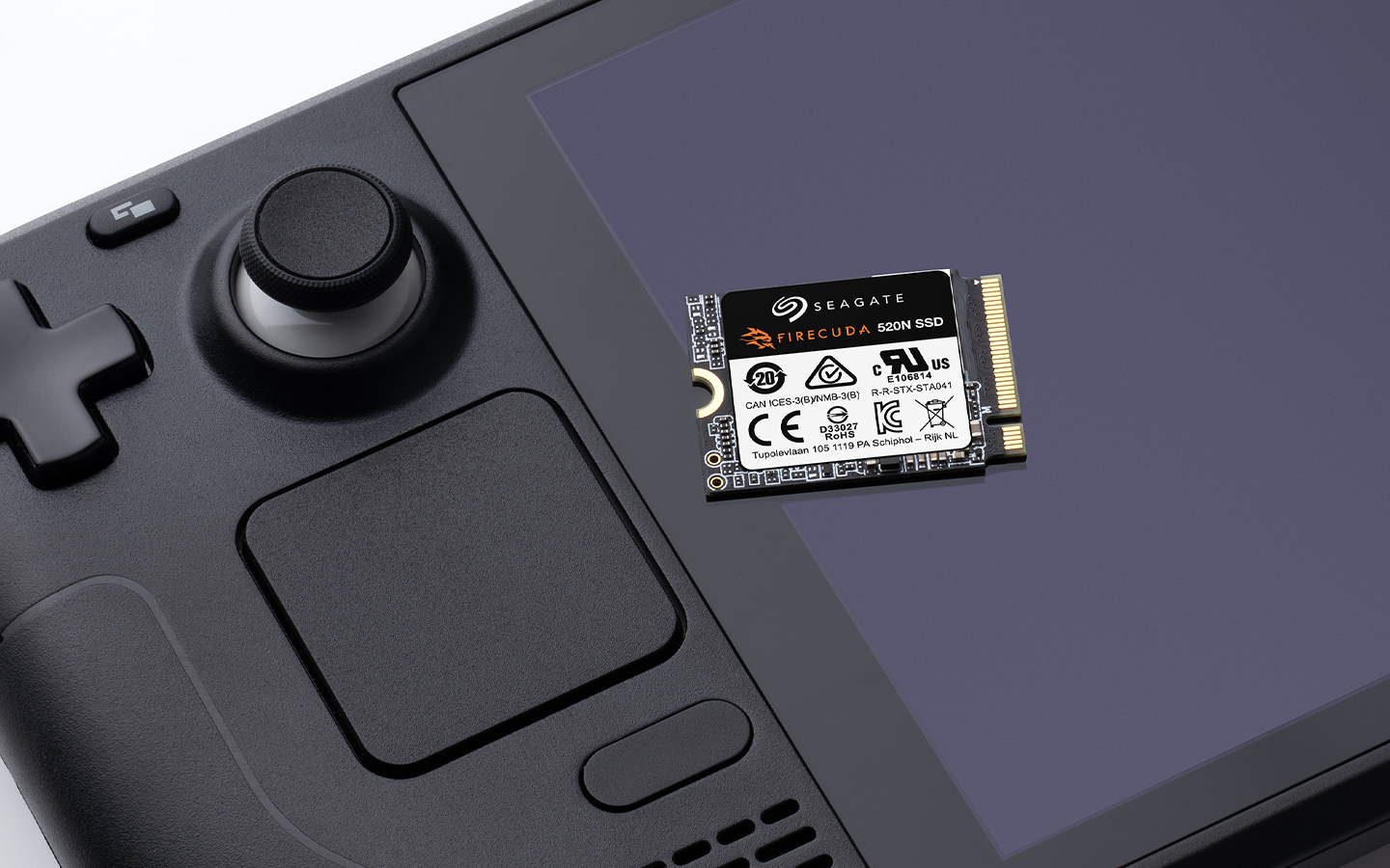 Seagate FireCuda SSD rests on a Steam Deck handheld gaming device screen, showing a close-up of gaming storage hardware.