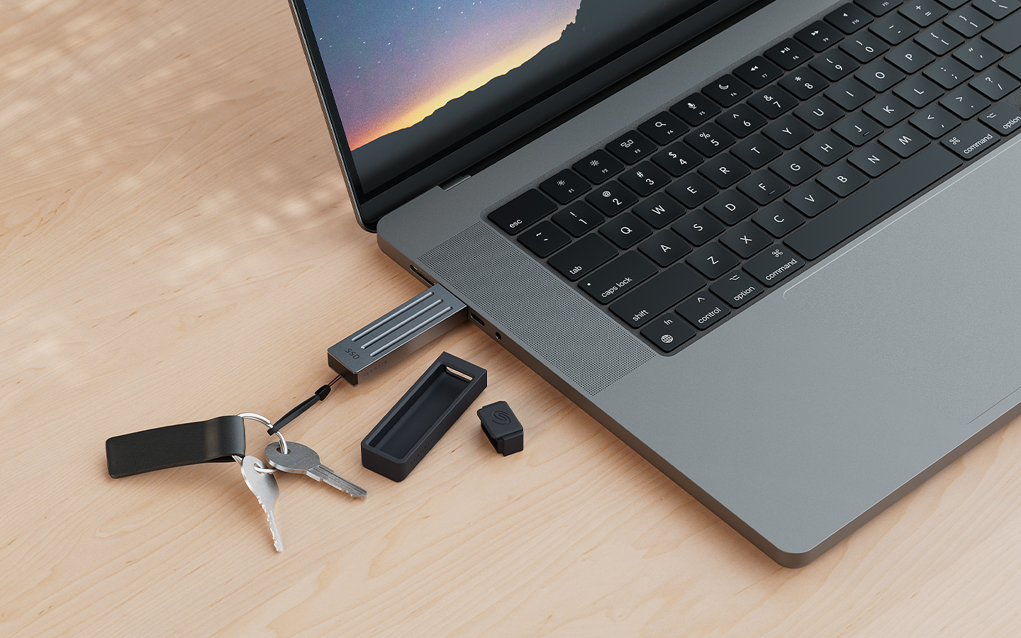 Seagate Ultra Compact external SSD on a keychain is plugged into a MacBook Pro via USB-C, highlighting its portable, on-the-go design.