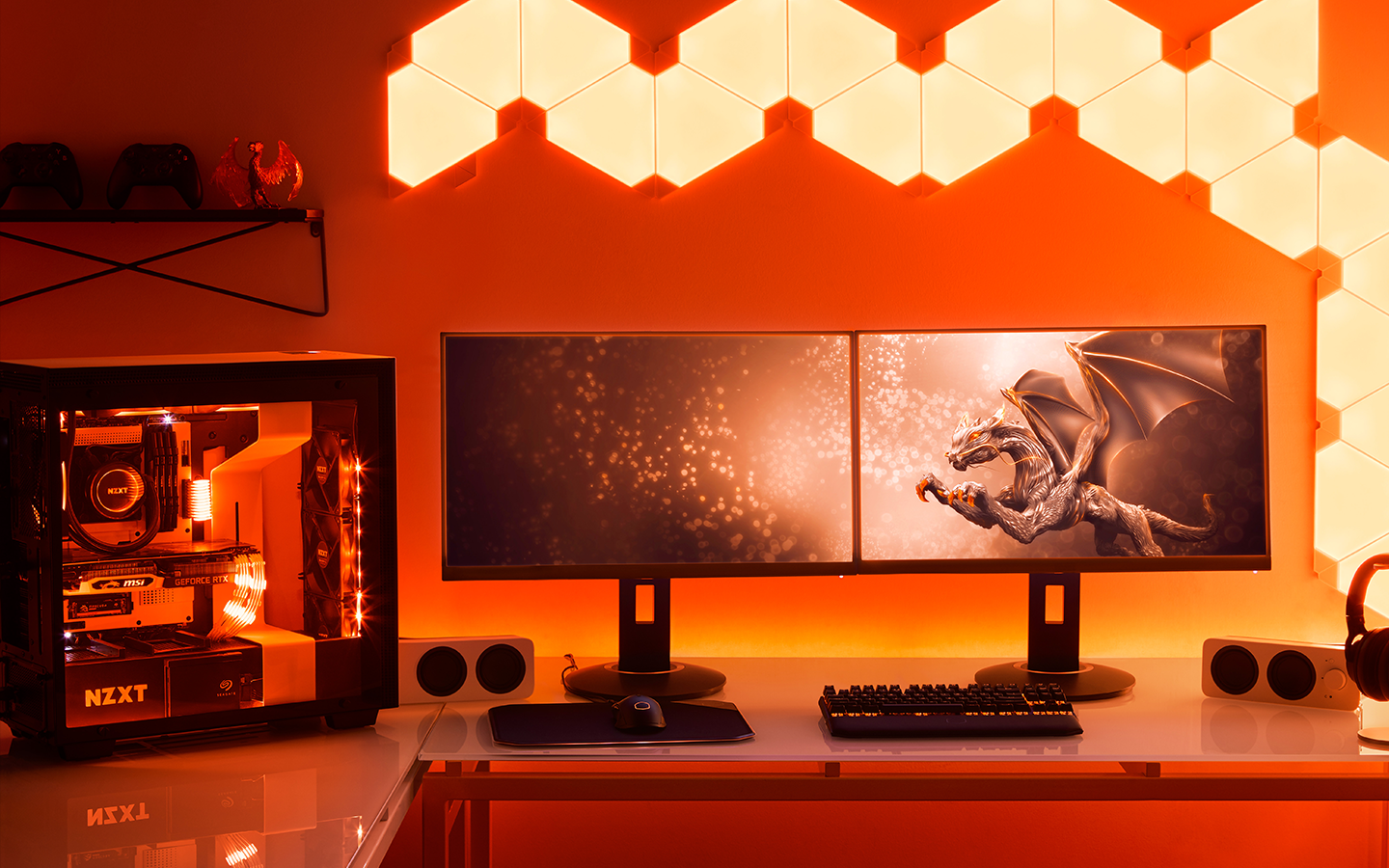 See-through hard drive is displayed next to mini speakers, dual screens, and headphones as part of a gaming set up.