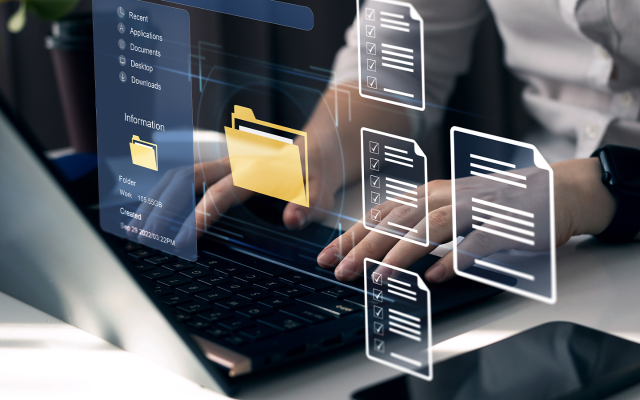 File and document icons overlay an image of a person typing on a laptop with a phone nearby, symbolizing productive work.