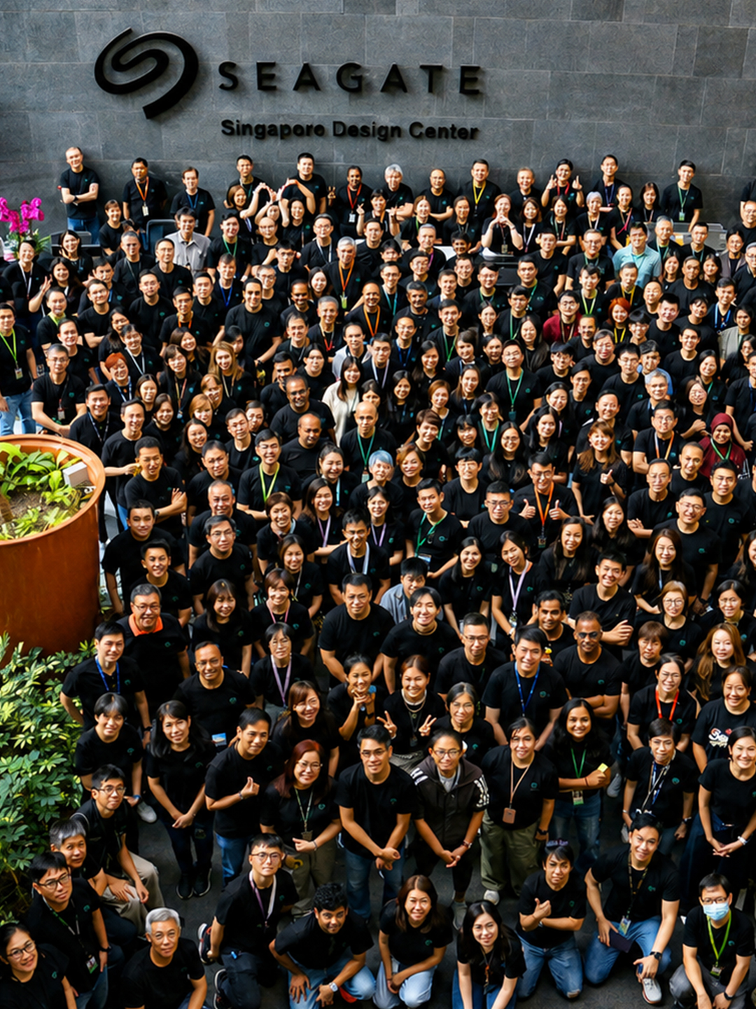 Large group of people stand outside the Seagate Singapore Design Center and look up for a group photo.