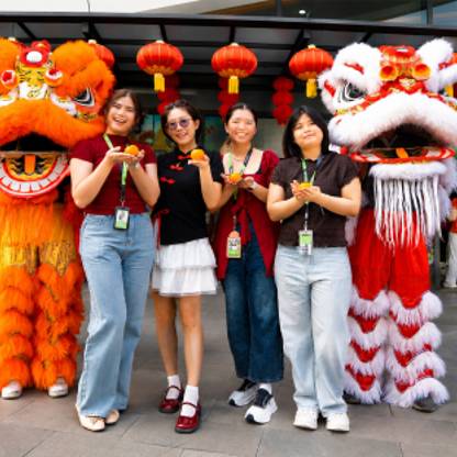 Four Seagate employees pose with lion dance performers during a Lunar New Year celebration. 