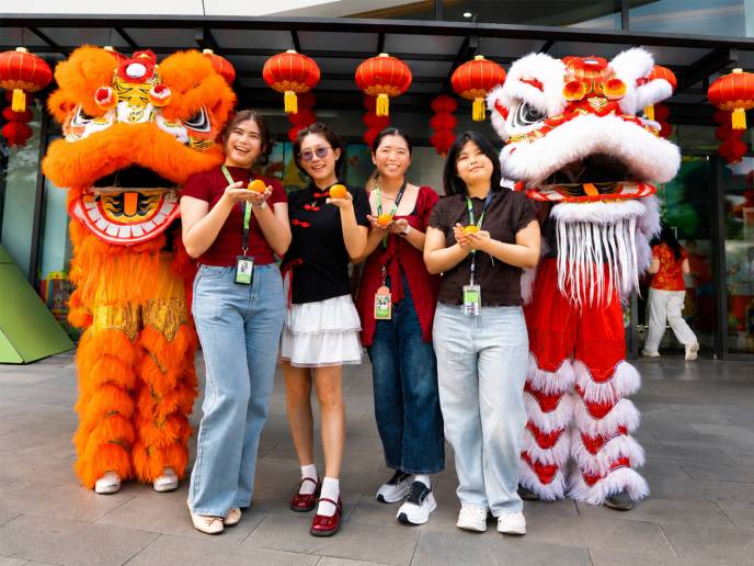 Four Seagate employees pose with lion dance performers during a Lunar New Year celebration. 