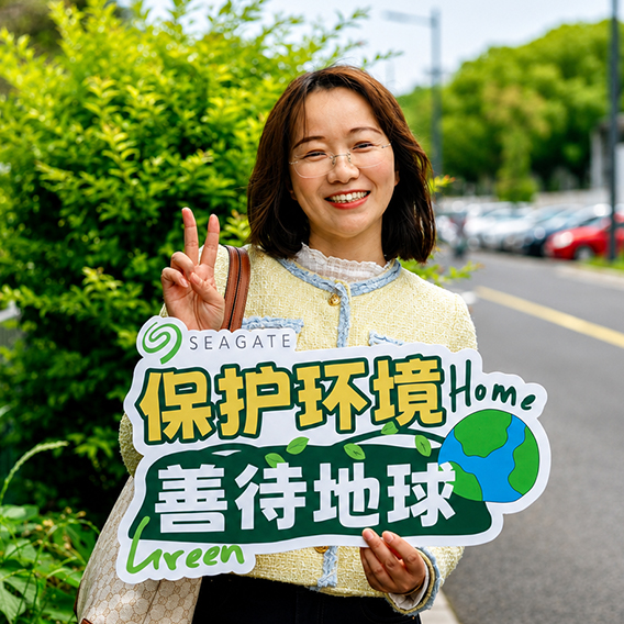 Seagate employee holding a sign promoting environmental stewardship at a company sustainability event.
