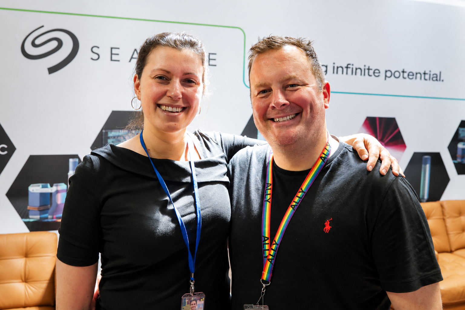 Two employees stand together at a Seagate event booth featuring company branding in the background. 