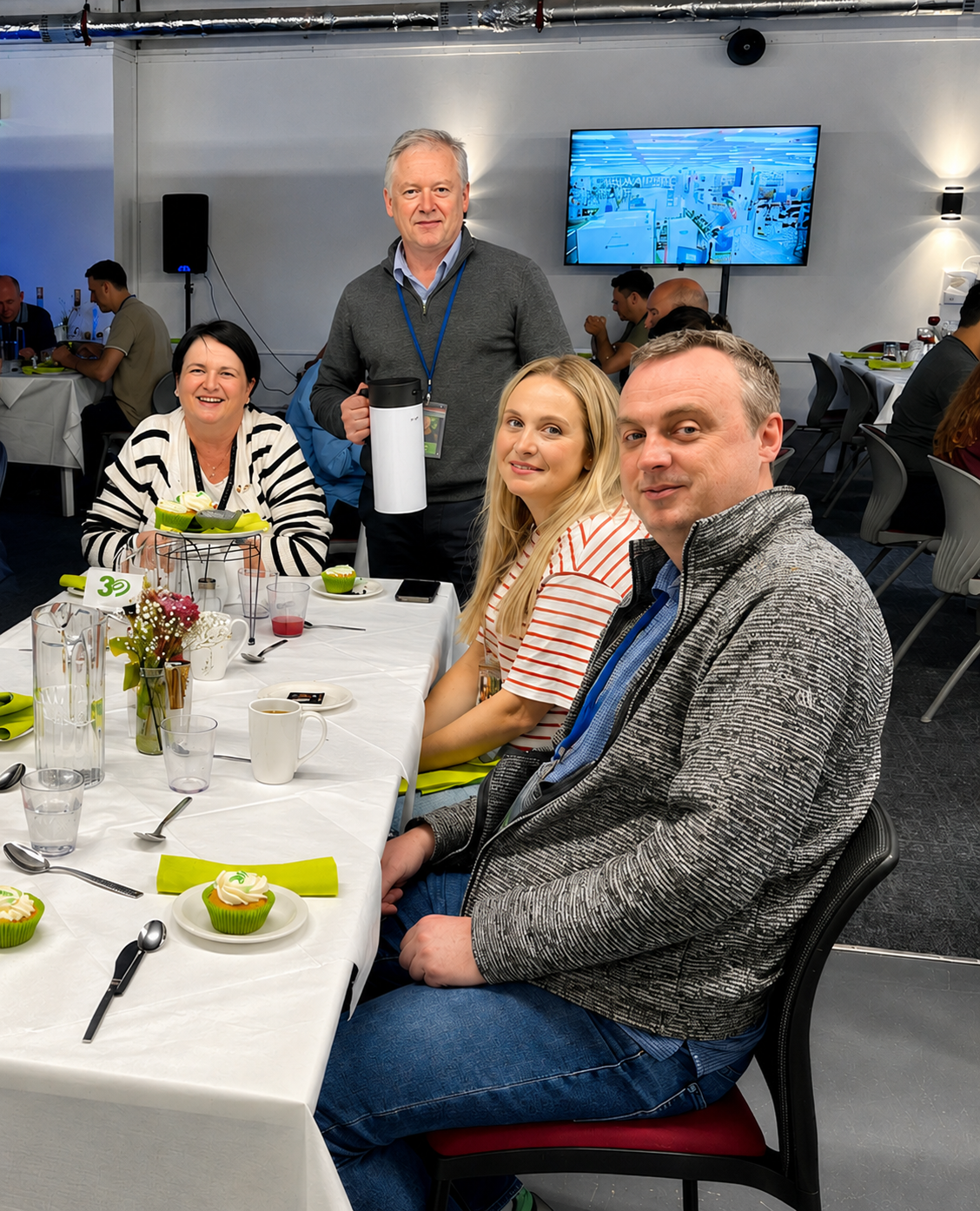 Employees seated around a dining table attend a company event. 
