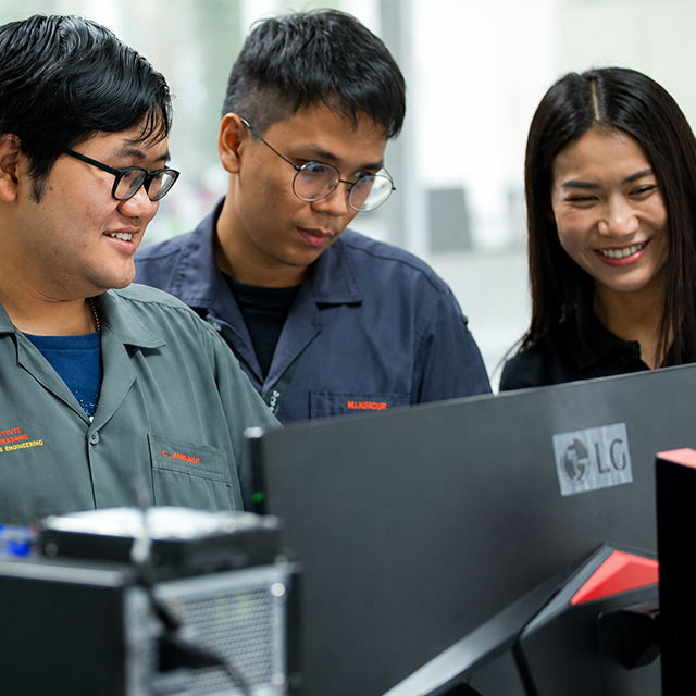 Three Seagate employees reviewing work together at a workstation.