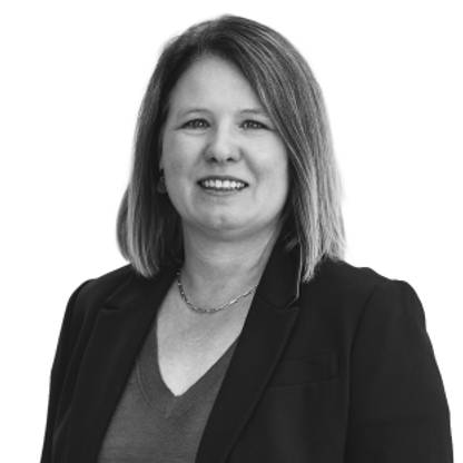 Black-and-white headshot of a Karin Werder with shoulder-length hair in a blazer, facing camera against a plain background.