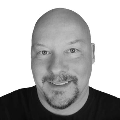 Black-and-white headshot of Nick Jarvis, who’s facing the camera and standing against a light background.